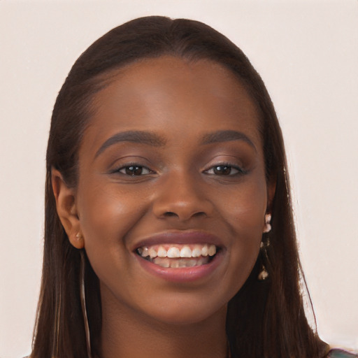 Joyful black young-adult female with long  brown hair and brown eyes