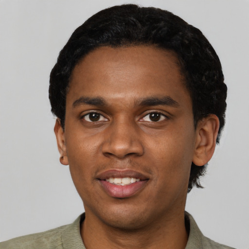 Joyful black young-adult male with short  black hair and brown eyes