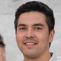 Joyful white young-adult male with short  black hair and brown eyes