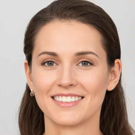 Joyful white young-adult female with long  brown hair and grey eyes