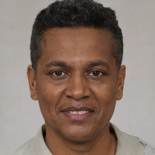Joyful black adult male with short  brown hair and brown eyes