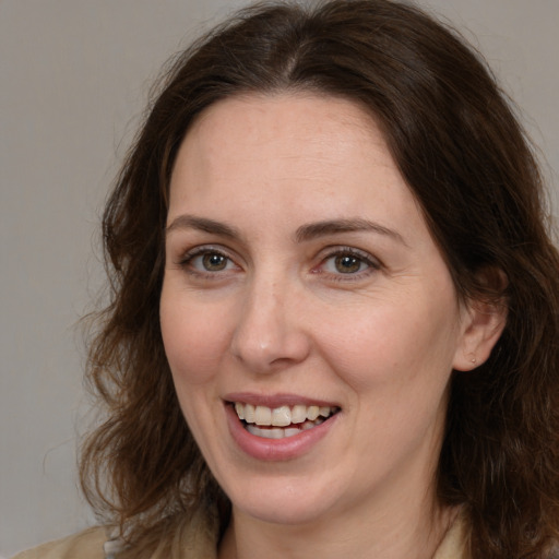 Joyful white adult female with medium  brown hair and brown eyes