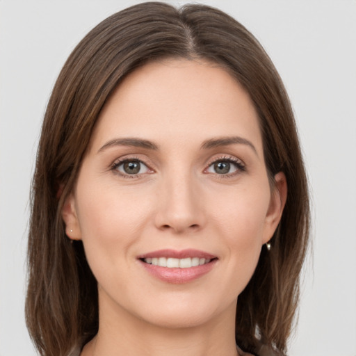 Joyful white young-adult female with medium  brown hair and grey eyes