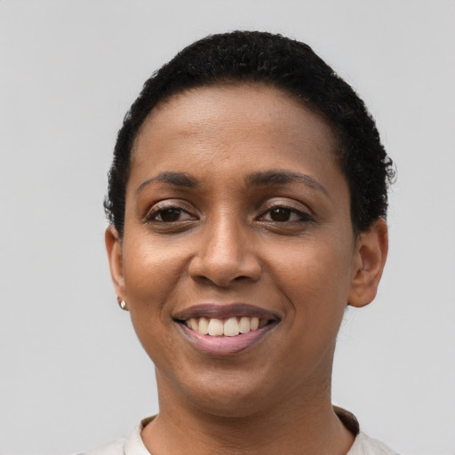 Joyful black young-adult female with short  black hair and brown eyes