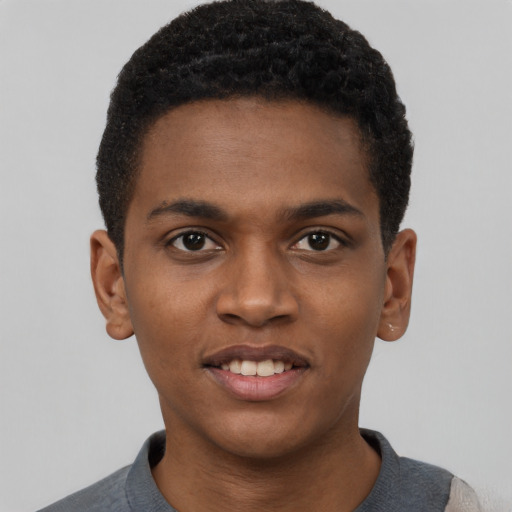Joyful black young-adult male with short  brown hair and brown eyes