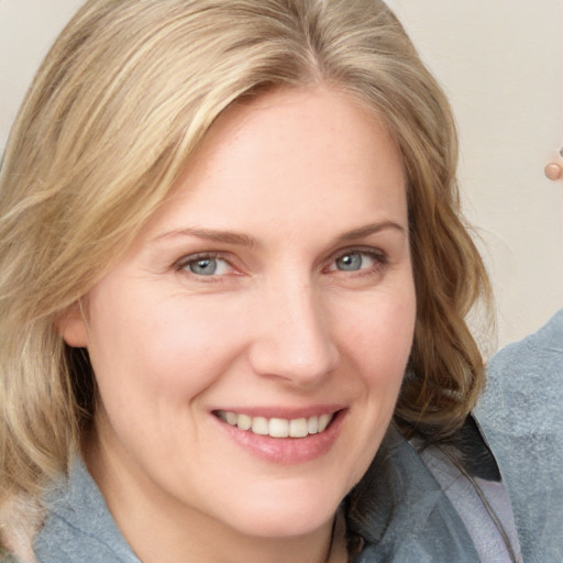 Joyful white young-adult female with medium  brown hair and blue eyes