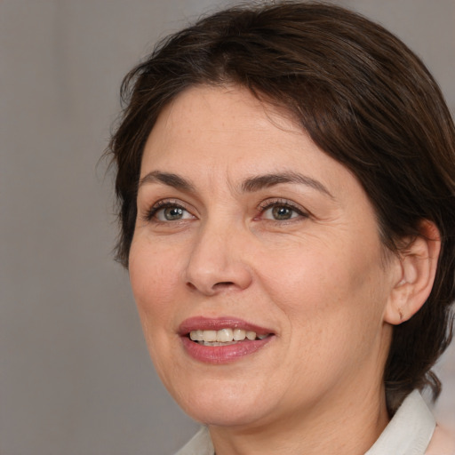 Joyful white adult female with medium  brown hair and brown eyes