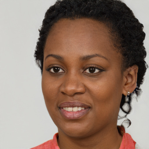 Joyful black young-adult female with short  brown hair and brown eyes