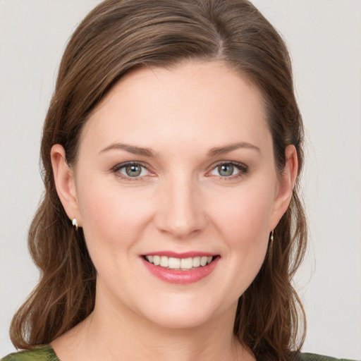 Joyful white young-adult female with medium  brown hair and green eyes