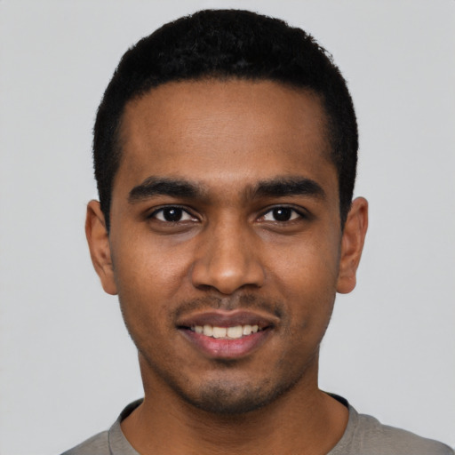 Joyful black young-adult male with short  black hair and brown eyes