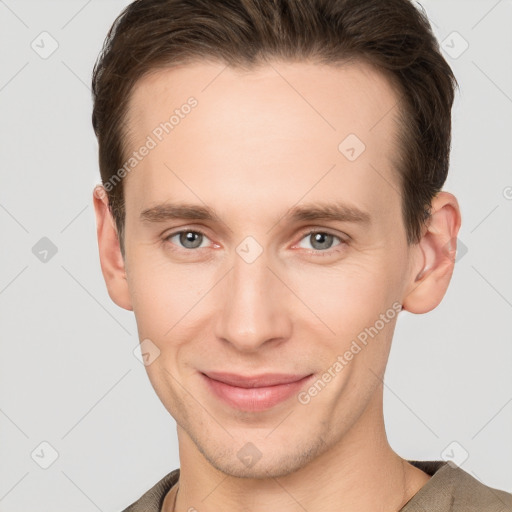 Joyful white young-adult male with short  brown hair and grey eyes