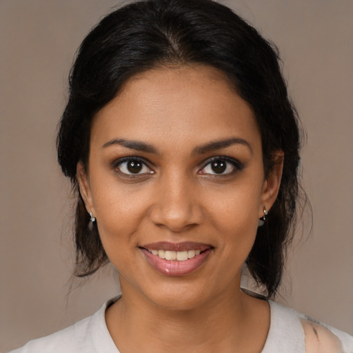 Joyful black young-adult female with medium  brown hair and brown eyes