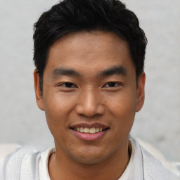 Joyful asian young-adult male with short  black hair and brown eyes