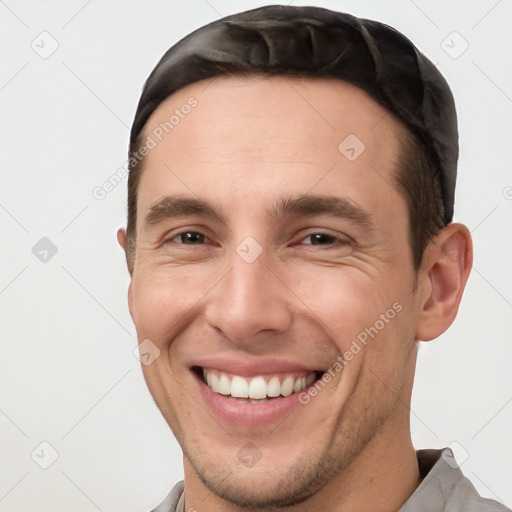 Joyful white young-adult male with short  brown hair and brown eyes