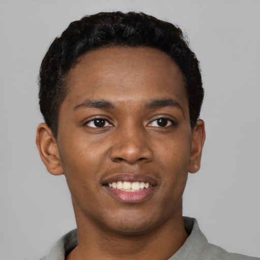 Joyful black young-adult male with short  black hair and brown eyes