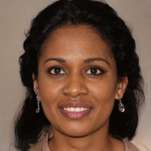 Joyful black young-adult female with long  black hair and brown eyes