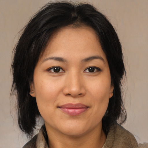 Joyful asian adult female with medium  brown hair and brown eyes