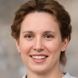 Joyful white young-adult female with medium  brown hair and green eyes