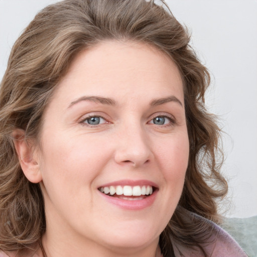 Joyful white young-adult female with medium  brown hair and blue eyes