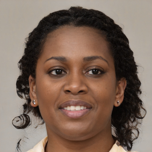Joyful black young-adult female with medium  brown hair and brown eyes