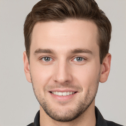 Joyful white young-adult male with short  brown hair and grey eyes