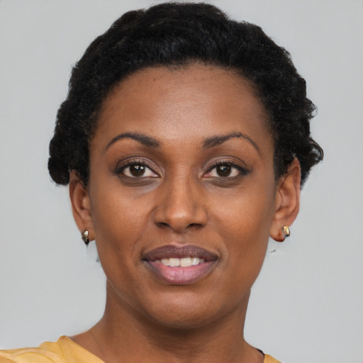 Joyful black young-adult female with short  brown hair and brown eyes