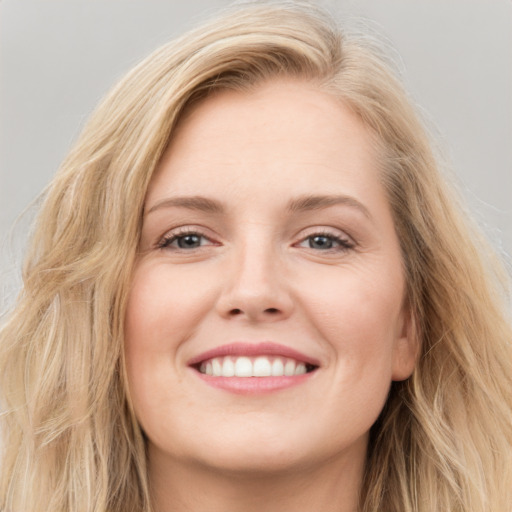 Joyful white young-adult female with long  brown hair and blue eyes