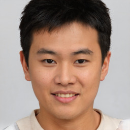 Joyful asian young-adult male with short  brown hair and brown eyes