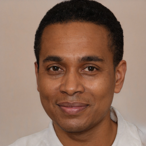 Joyful black adult male with short  black hair and brown eyes