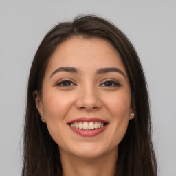 Joyful white young-adult female with long  brown hair and brown eyes