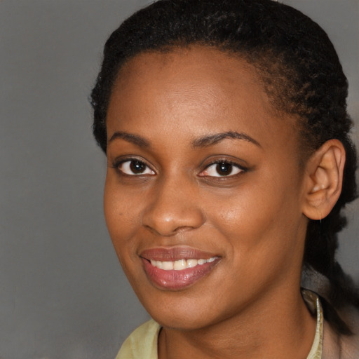 Joyful black young-adult female with long  brown hair and brown eyes