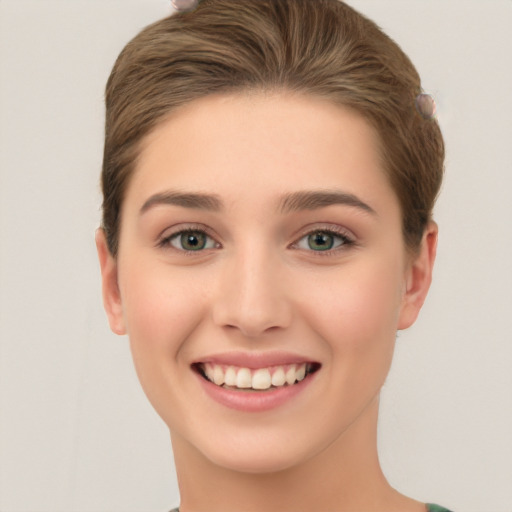 Joyful white young-adult female with short  brown hair and green eyes