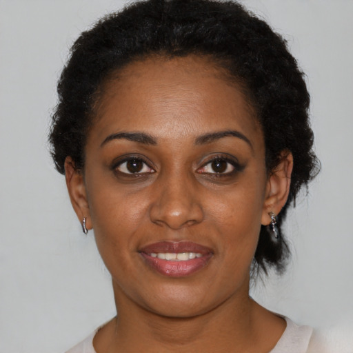 Joyful black young-adult female with short  black hair and brown eyes