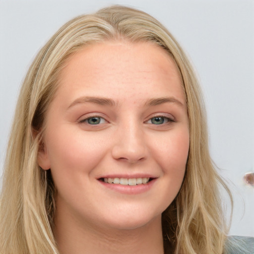 Joyful white young-adult female with long  brown hair and blue eyes