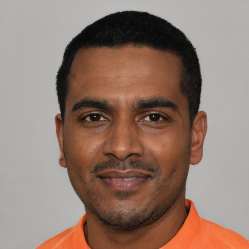 Joyful black young-adult male with short  black hair and brown eyes