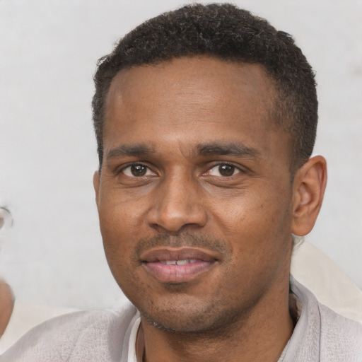 Joyful black adult male with short  black hair and brown eyes