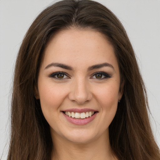 Joyful white young-adult female with long  brown hair and brown eyes