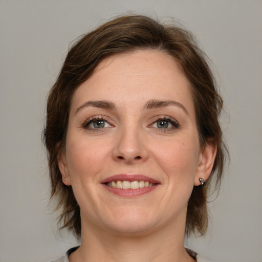 Joyful white young-adult female with medium  brown hair and green eyes