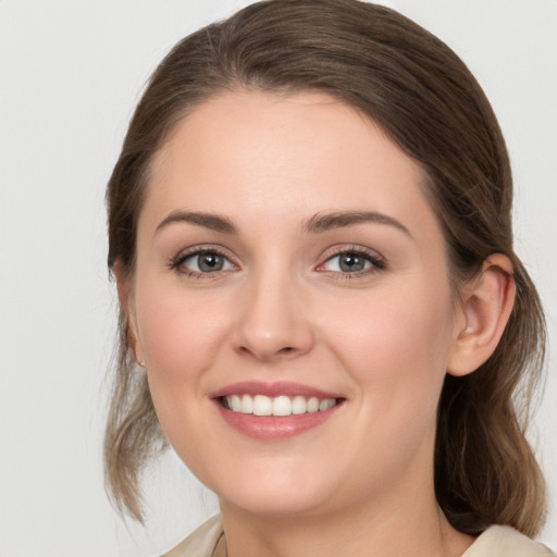 Joyful white young-adult female with medium  brown hair and grey eyes