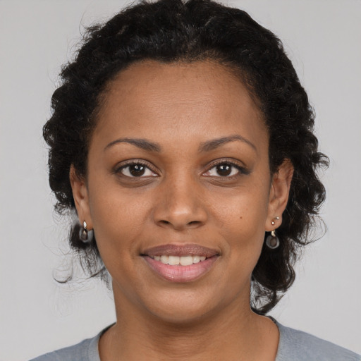 Joyful black young-adult female with medium  brown hair and brown eyes