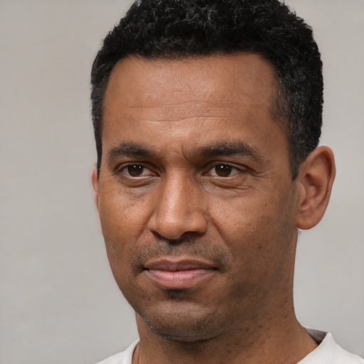 Joyful latino adult male with short  black hair and brown eyes
