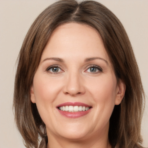 Joyful white adult female with medium  brown hair and brown eyes