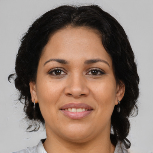 Joyful latino adult female with medium  brown hair and brown eyes