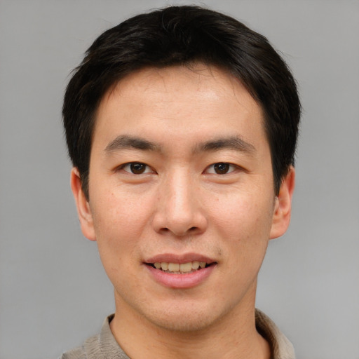Joyful asian young-adult male with short  brown hair and brown eyes