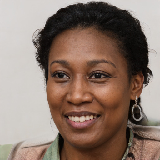 Joyful black adult female with short  brown hair and brown eyes