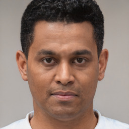 Joyful black young-adult male with short  black hair and brown eyes