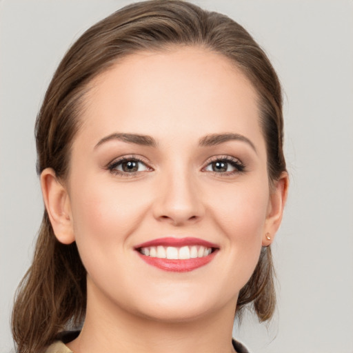 Joyful white young-adult female with medium  brown hair and grey eyes