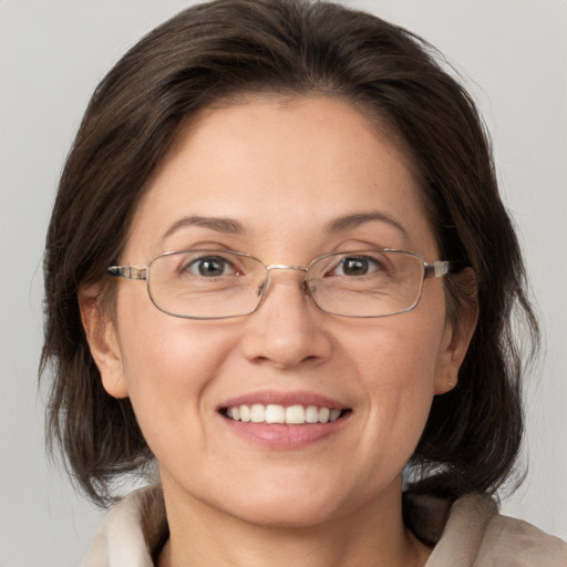 Joyful white adult female with medium  brown hair and blue eyes