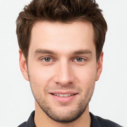 Joyful white young-adult male with short  brown hair and grey eyes