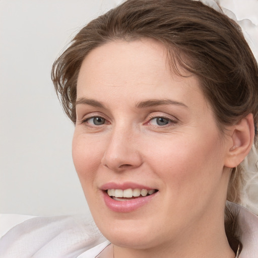 Joyful white young-adult female with medium  brown hair and grey eyes